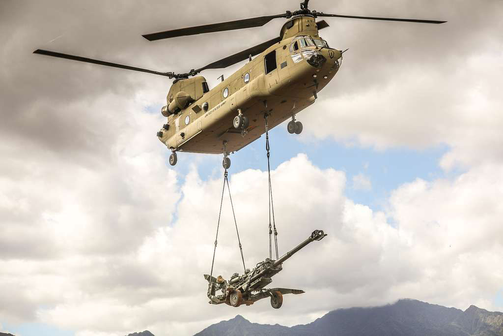 A U.S. military CH-47 Chinook helicopter carries a sling load with a M777 Howitzer "in preparation for a capabilities demonstration" in Hawaii