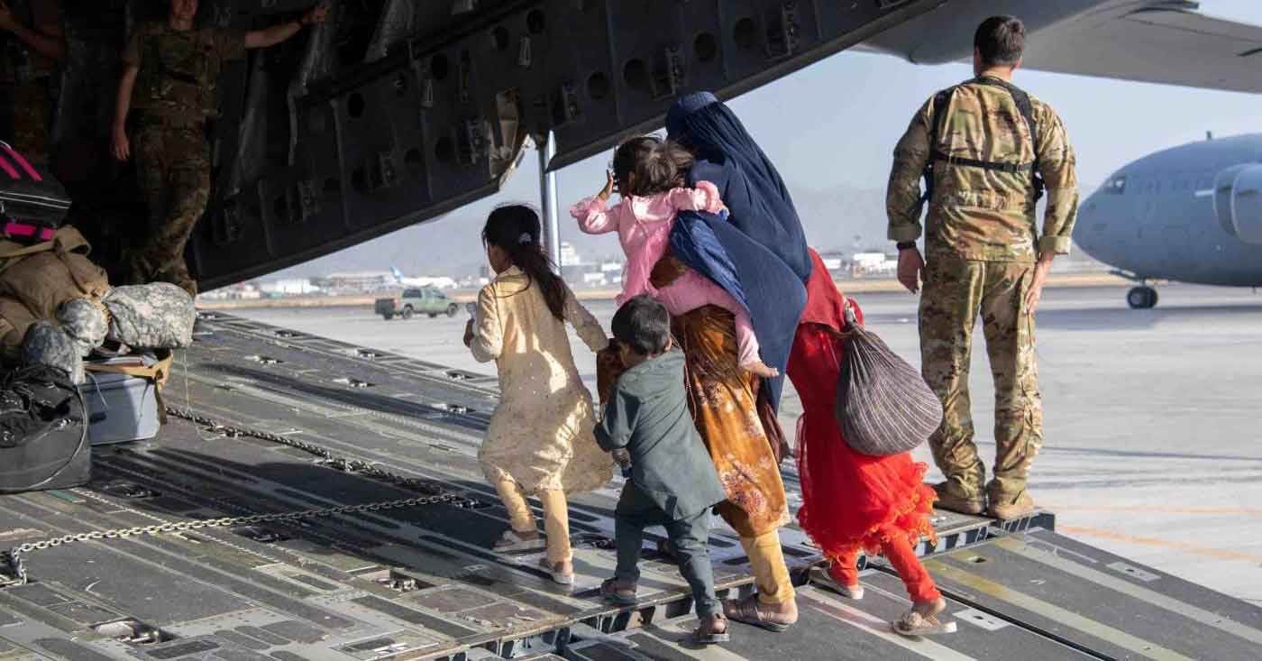 A refugee family walks onto a military plane in Afghanistan