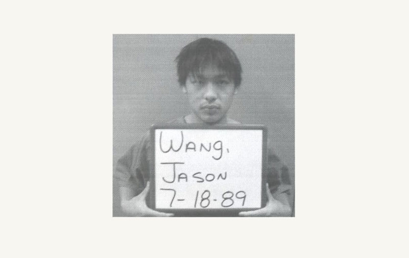 Jason Wang's prison mugshot - holding a sign with his name and birthday on it