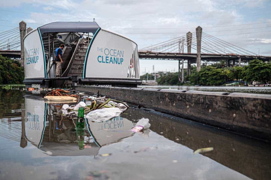 A boat intercepts trash on a river