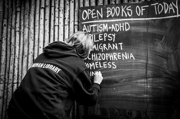 someone is writing on a chalkboard to raise awareness at the Human Library