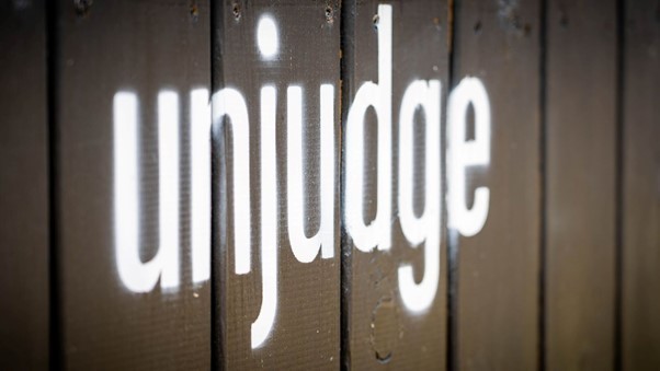 paint which reads 'unjudge' on a wall at the human library