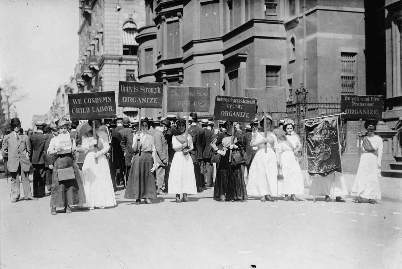 Historic photo ofwWomen demonstrating against child labor in New York City in the early 1900's — carrying signs that say things like "We condemn child labor" and"Unity is Strength - Organize"