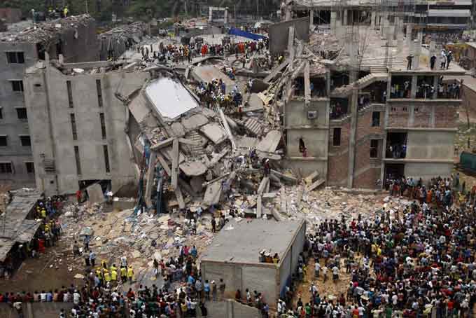 An aerial view of the Rana Plaza building collapsed, with crowds of people gathered around the rubble