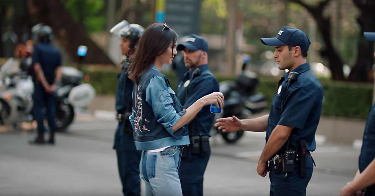 A screenshot of the Kendall Jenner Pepsi ad, showing her handing a police officer a can of soda