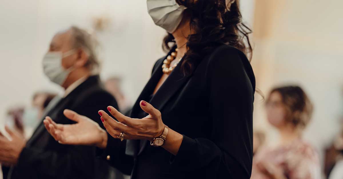 A woman wearing a face mask in church