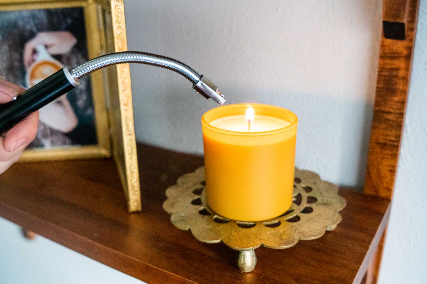 A rechargeable electric lighter with a flexible neck, lighting a candle