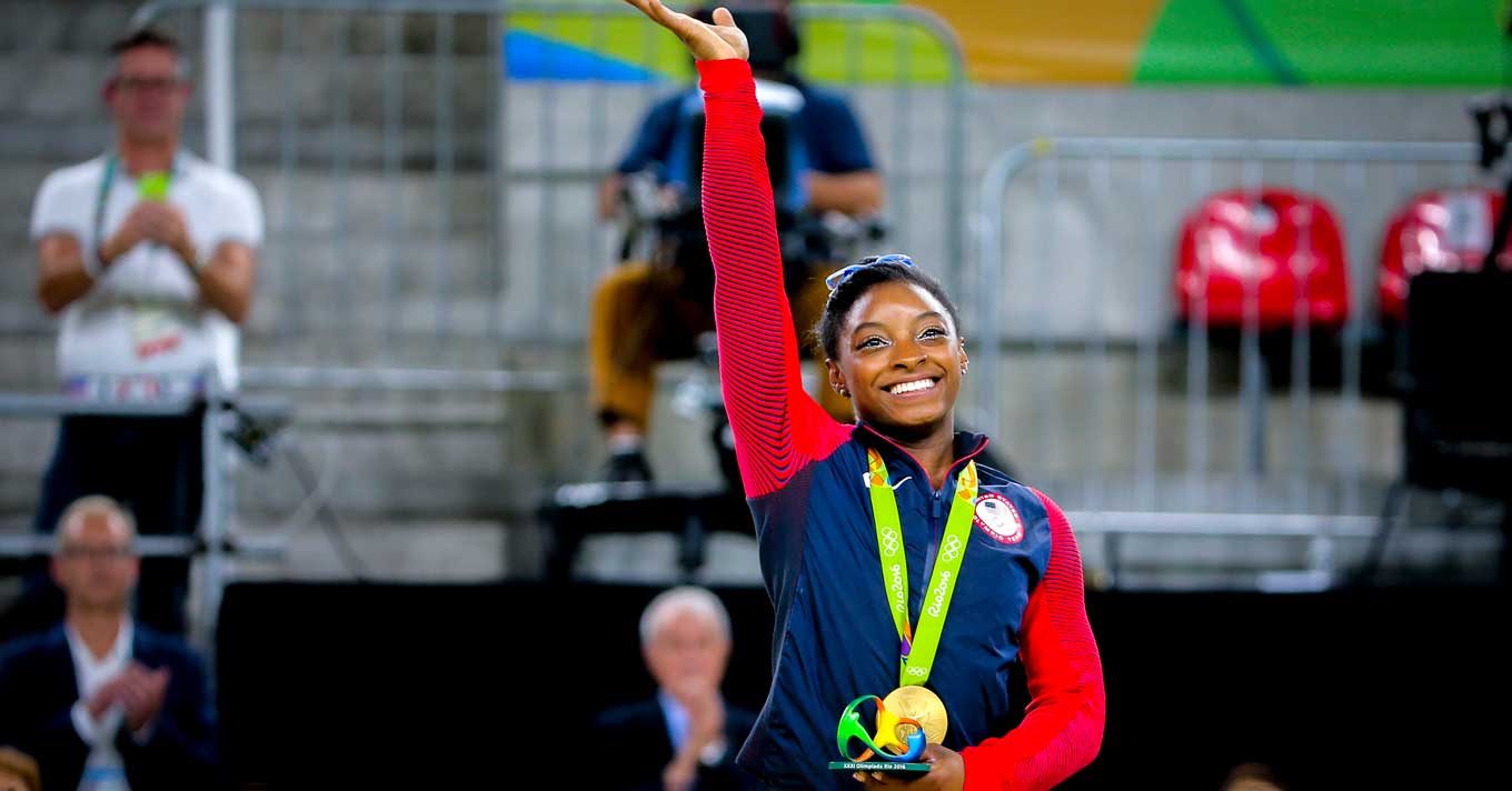 Simone Biles smiling after receiving a medal