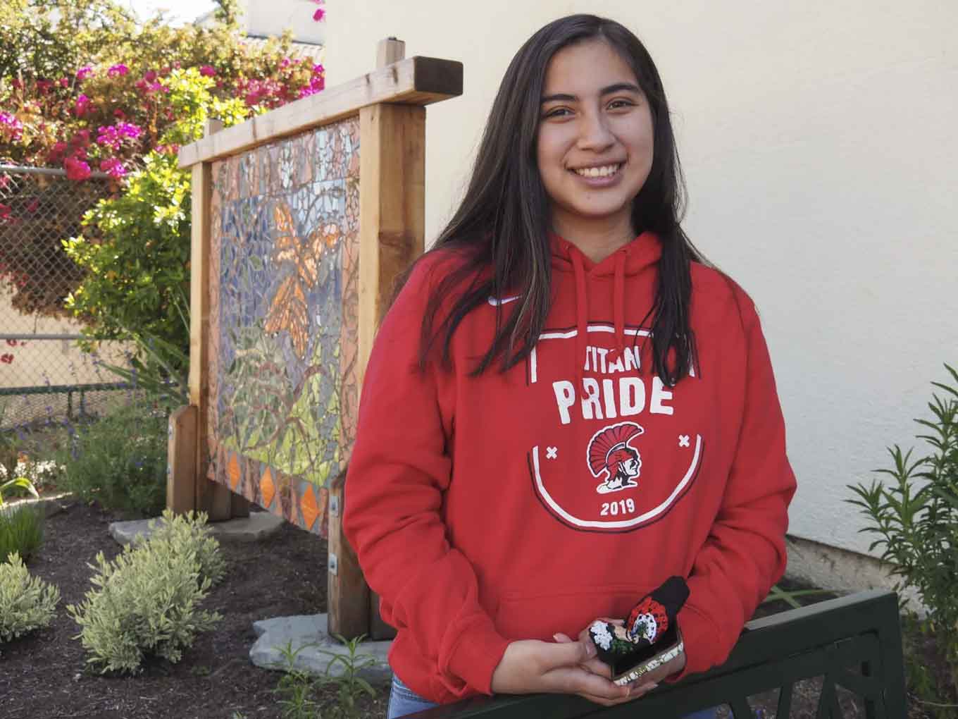 A freshman at UC Berkley wears a red "Tital Pride" sweatshirt and smiles for the camera