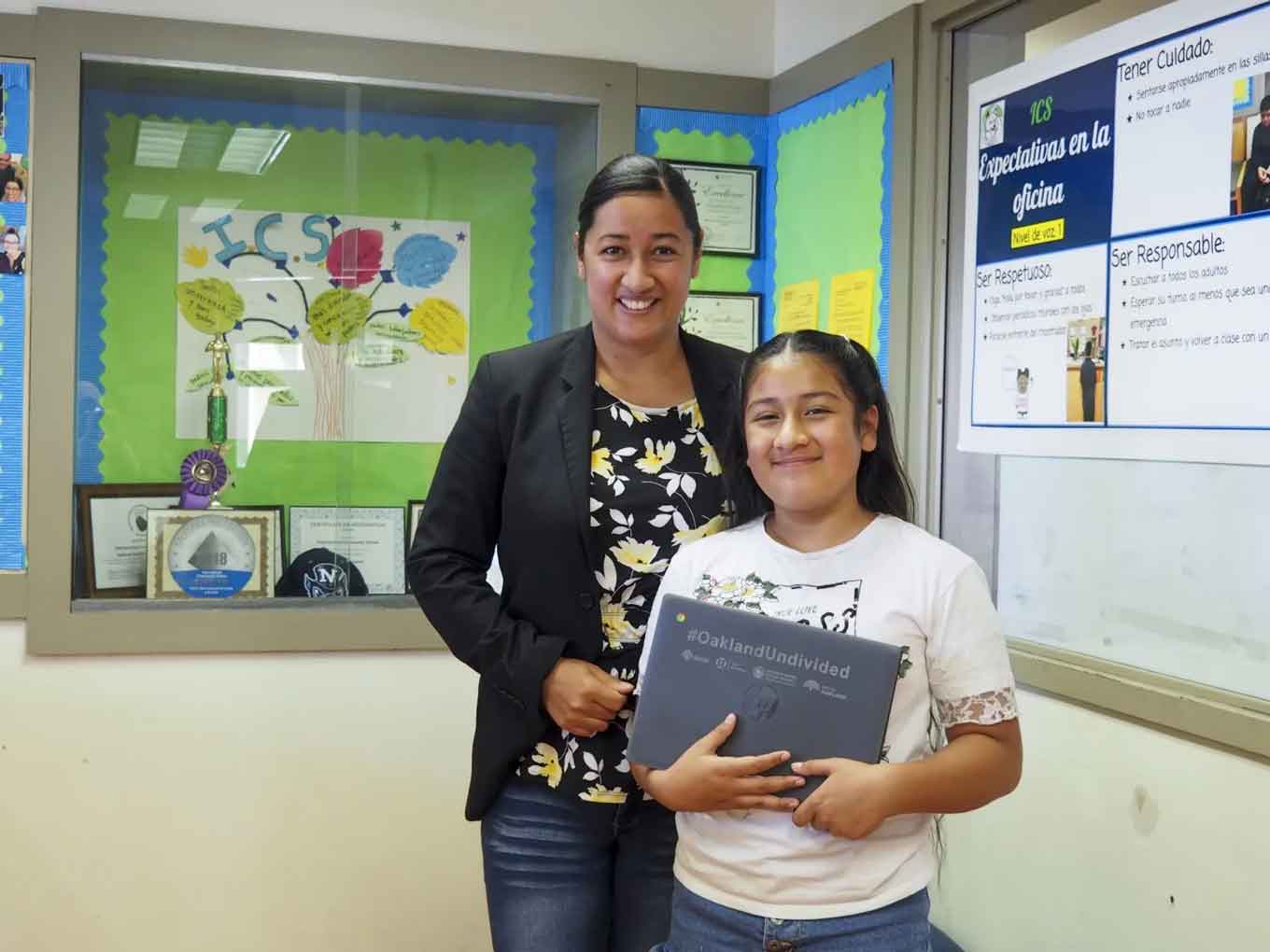 Maria G. Islas, a staff member at Think College Now, a public elementary school in Oakland, with her daughter, Jesimiel Merida-Islas, who received a laptop and hot spot after months of sharing a computer with her mother.