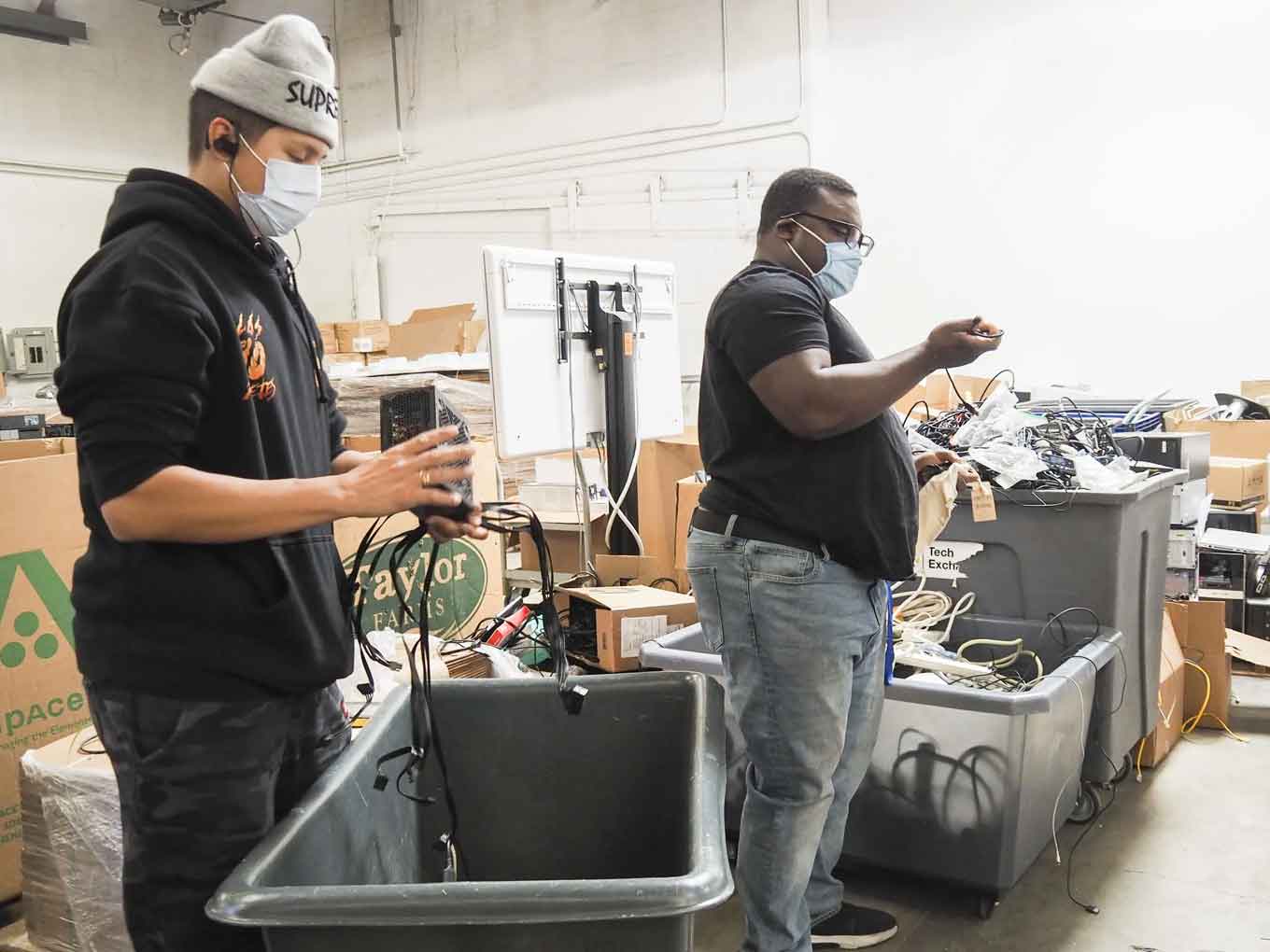 Tech Exchange warehouse staff sort through donated equipment. They and their Tech Hub colleagues spent months working on #OaklandUndivided devices that were then distributed to students in 2020 and 2021.