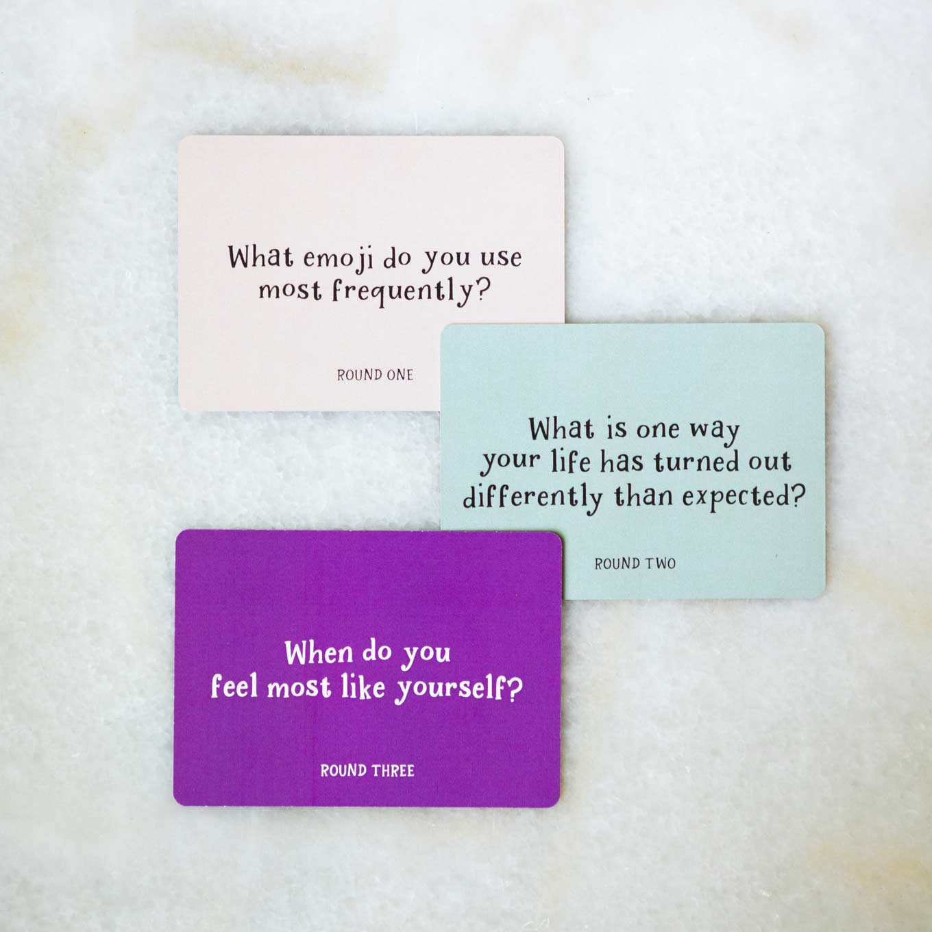 Colorful cards that read: What emoji do you use most frequently? What is one way your life has turned out differently than expected? When do you feel most like yourself?