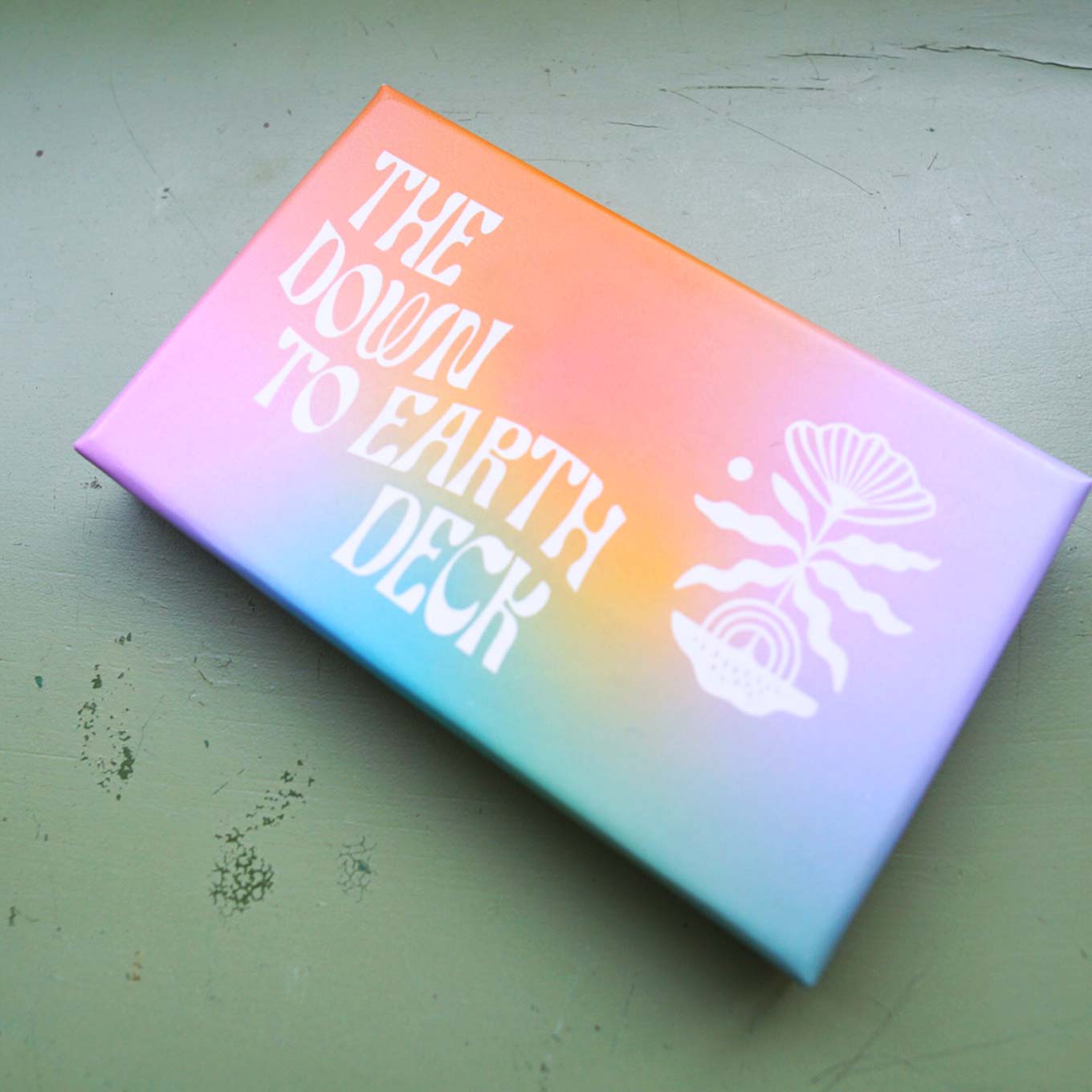 Colorful gradient box that says The Down To Earth Deck
