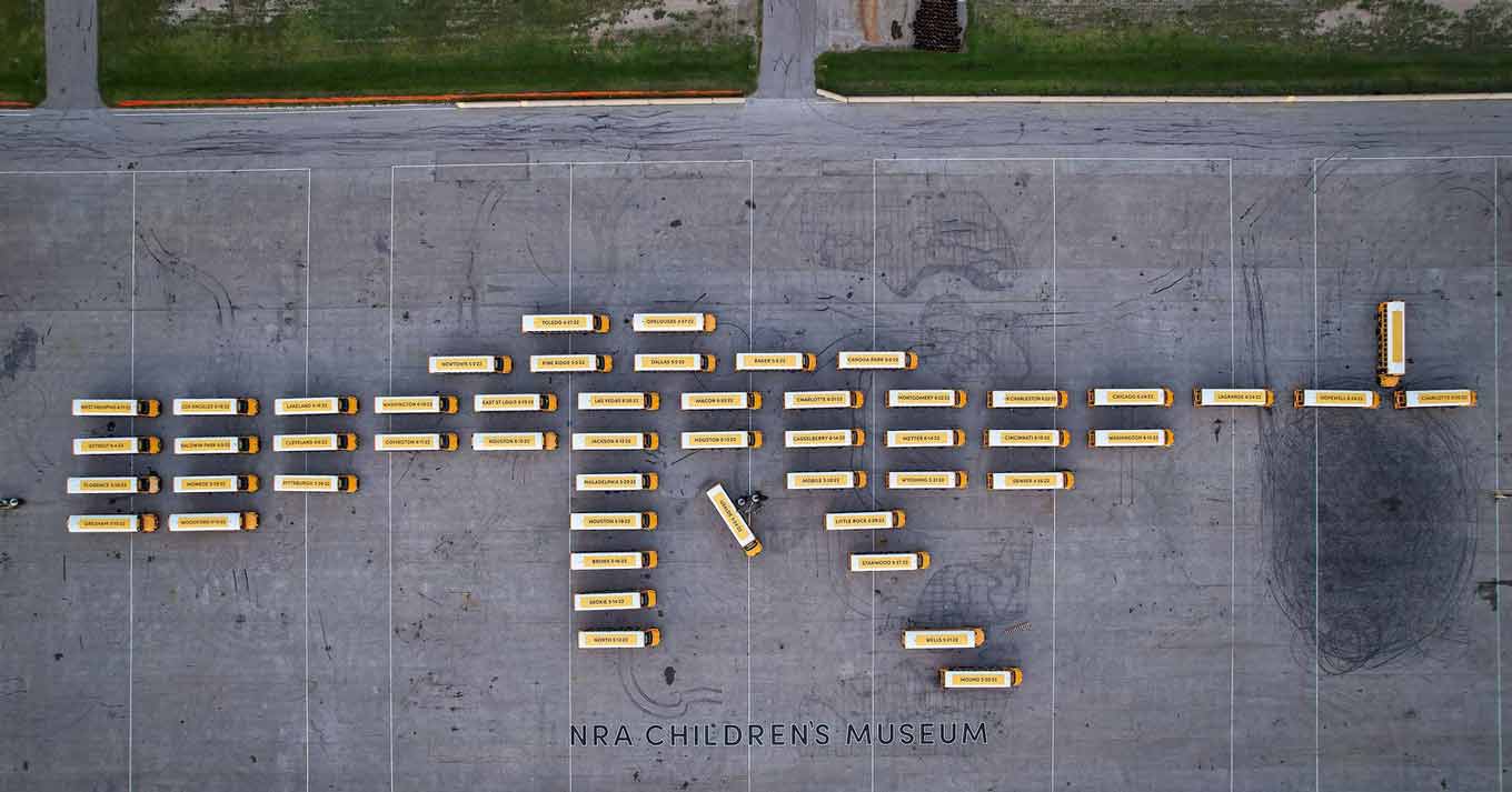 Dozens of school buses parked in the shape of a gun, with the words NRA Children's Museum