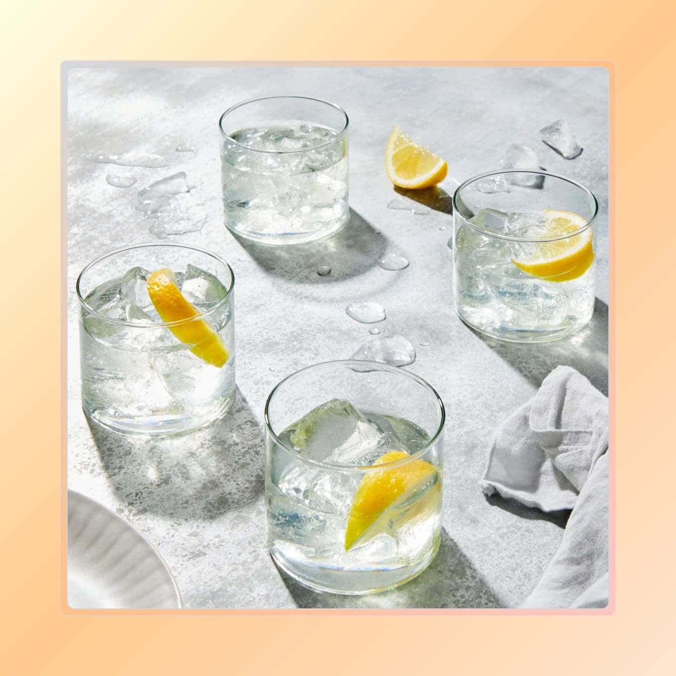 Four short drinking glasses with lemon cocktails
