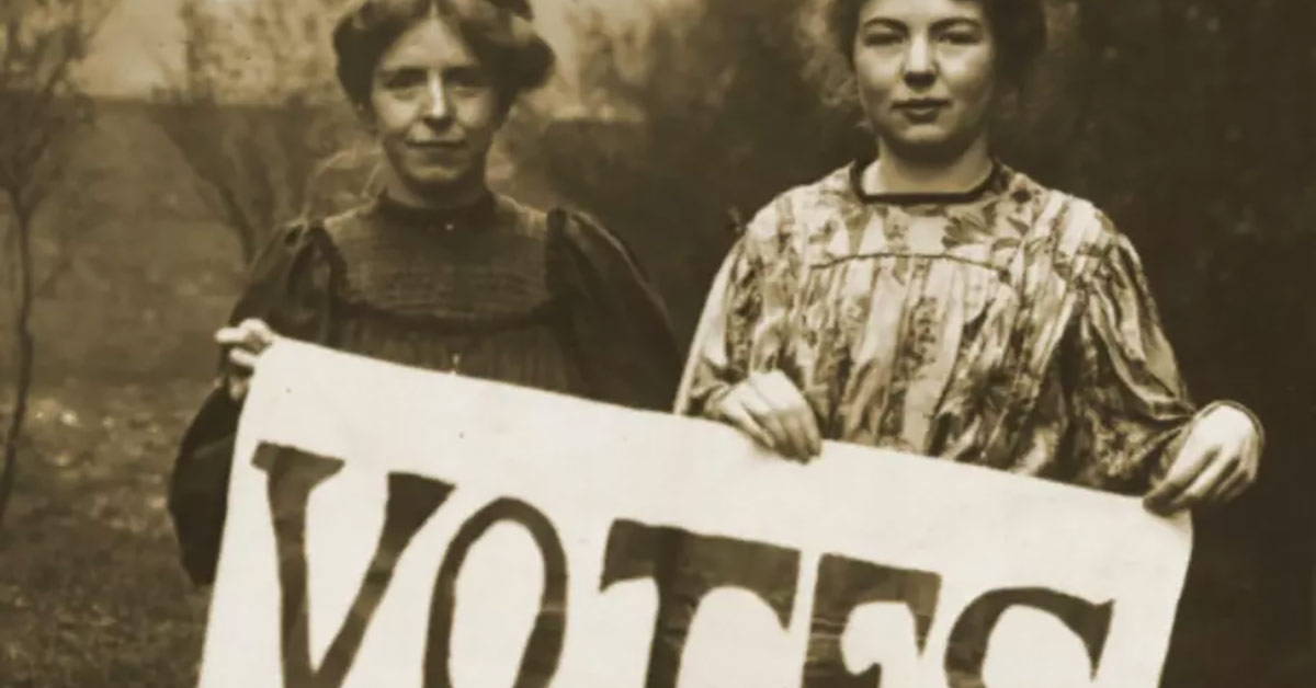 Two women holding a "vote" sign