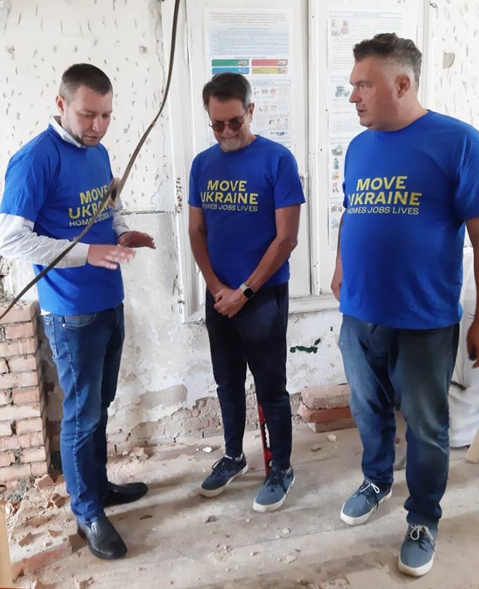 Members of the MoveUkraine team including John stand in a house being rebuilt