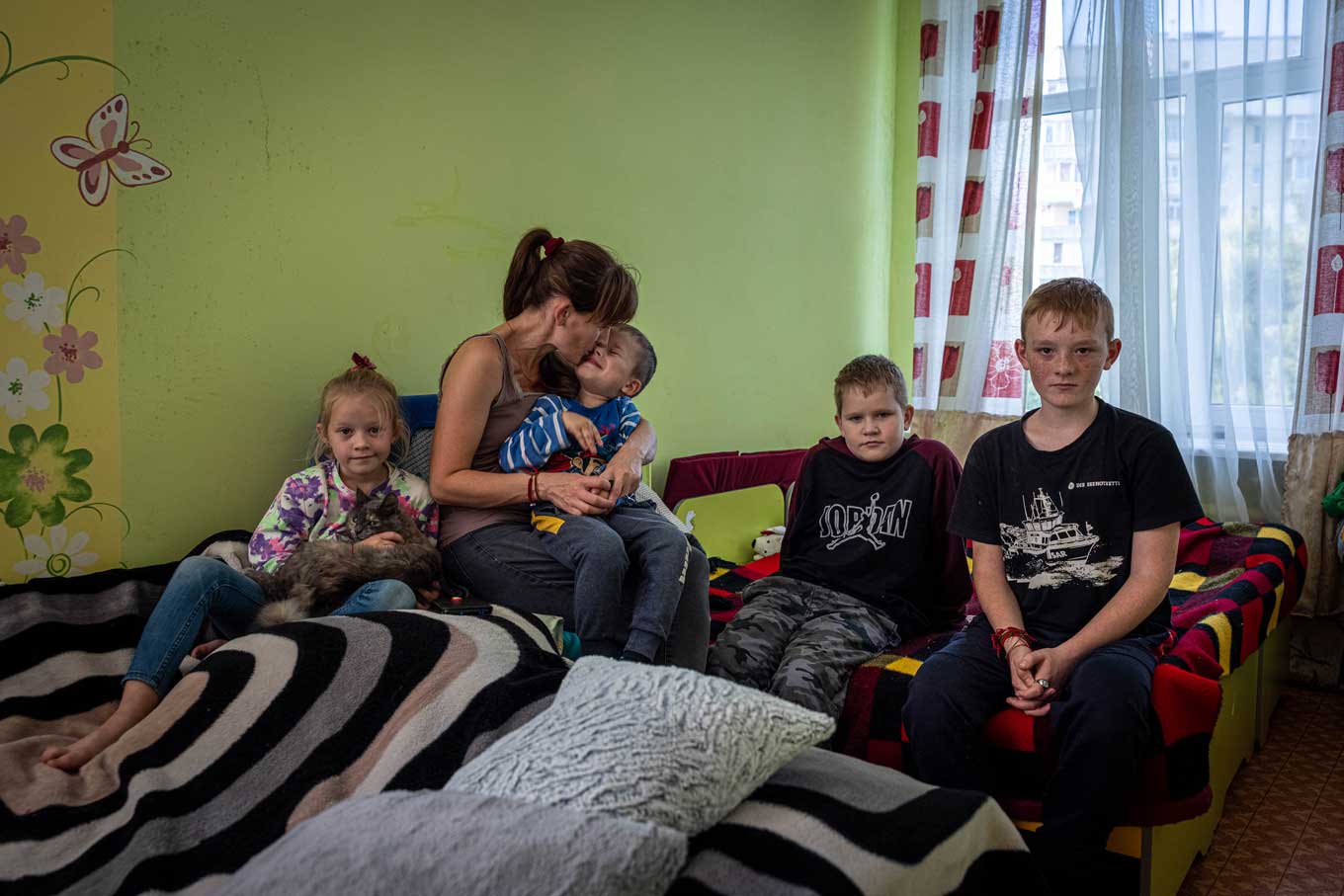 A Ukrainian mother poses with her children in a converted school