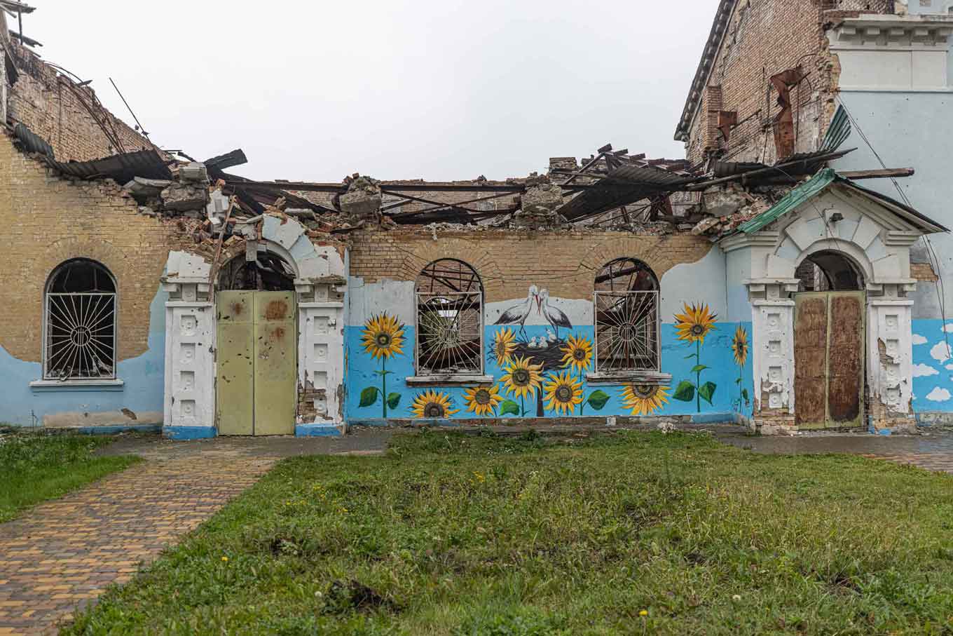 A destroyed building covered in paintings of sunflowers in Ukraine