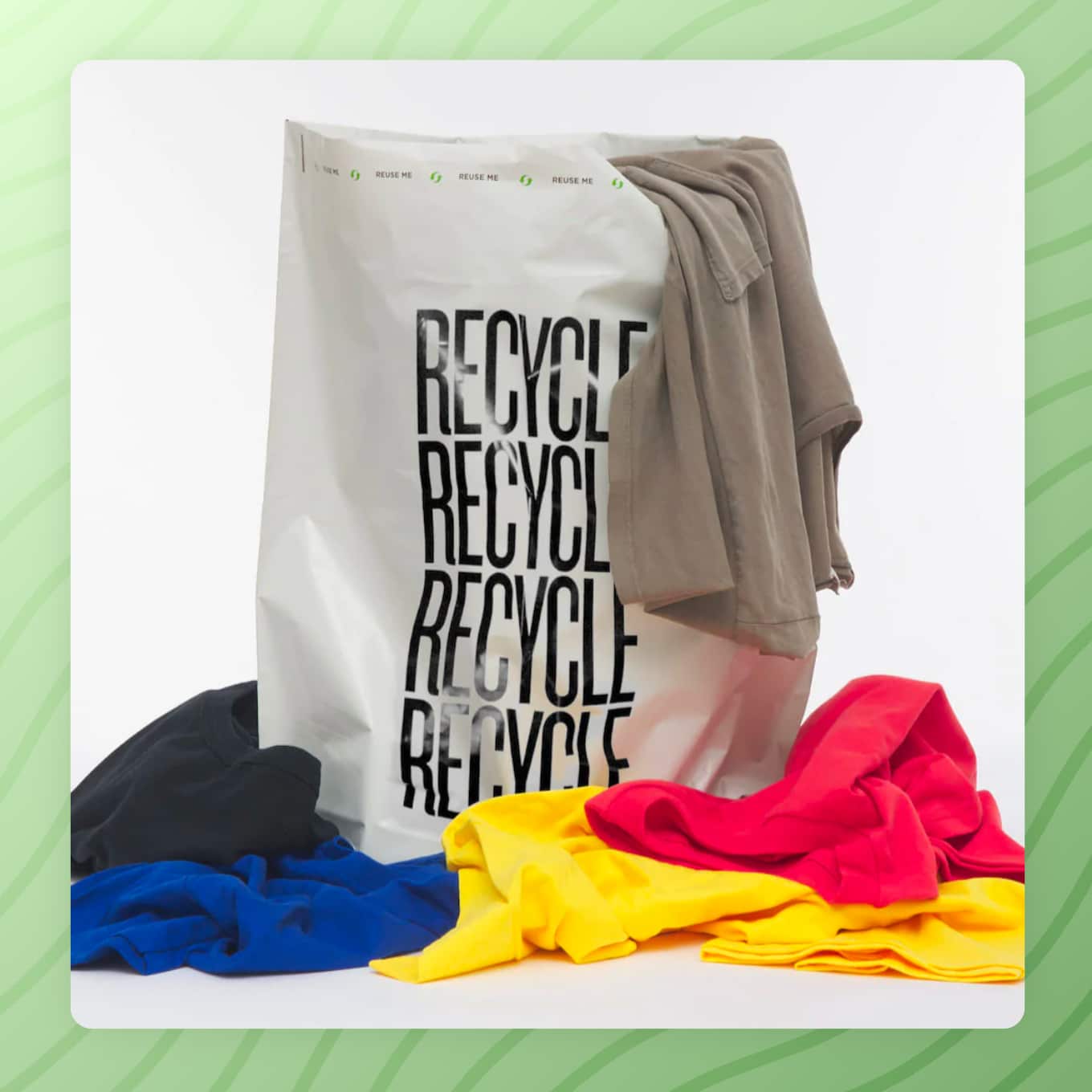 Plastic bag that rays "Recycle" with a bunch of clothes around it