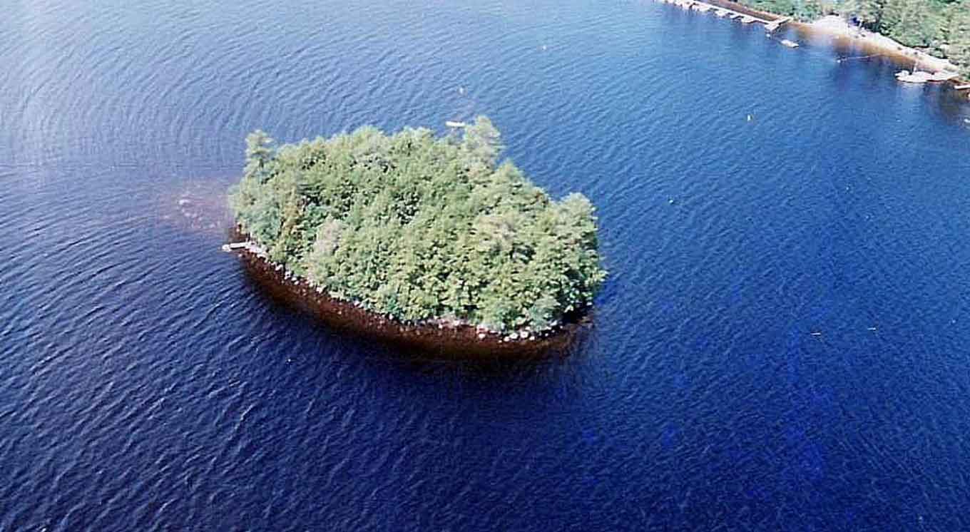An aerial photo of an Island covered in trees