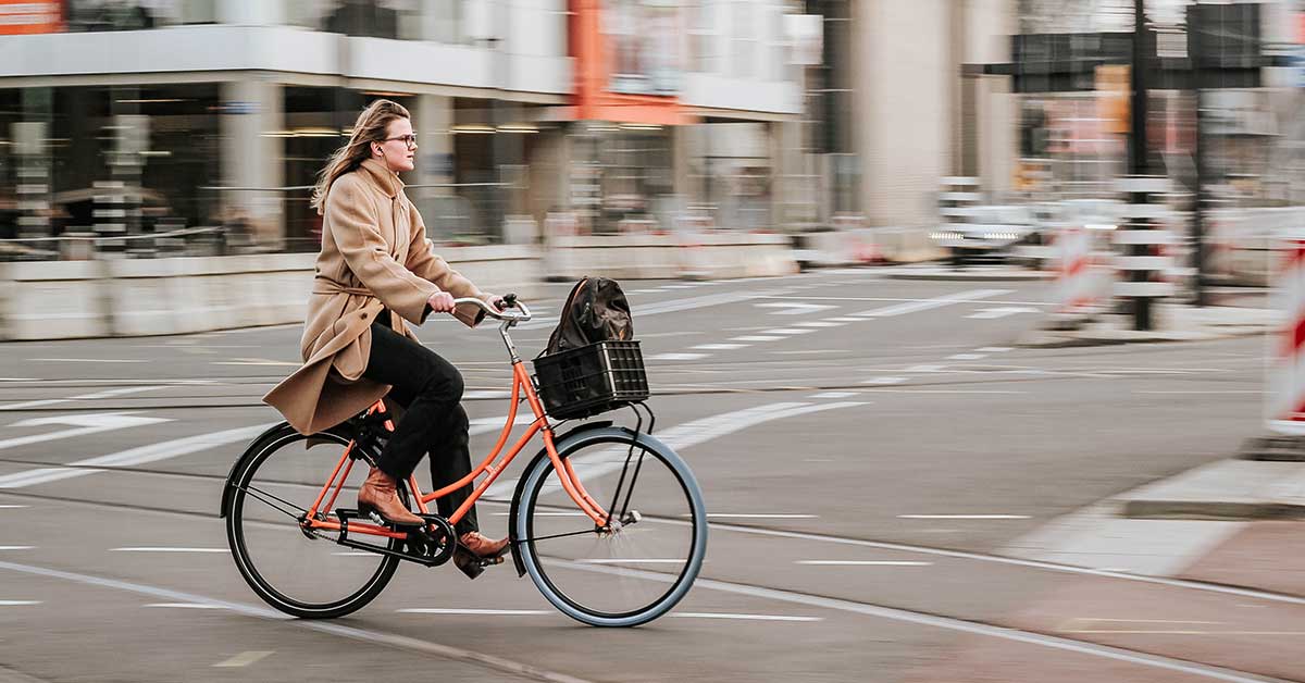 A woman on a bike riding across a street