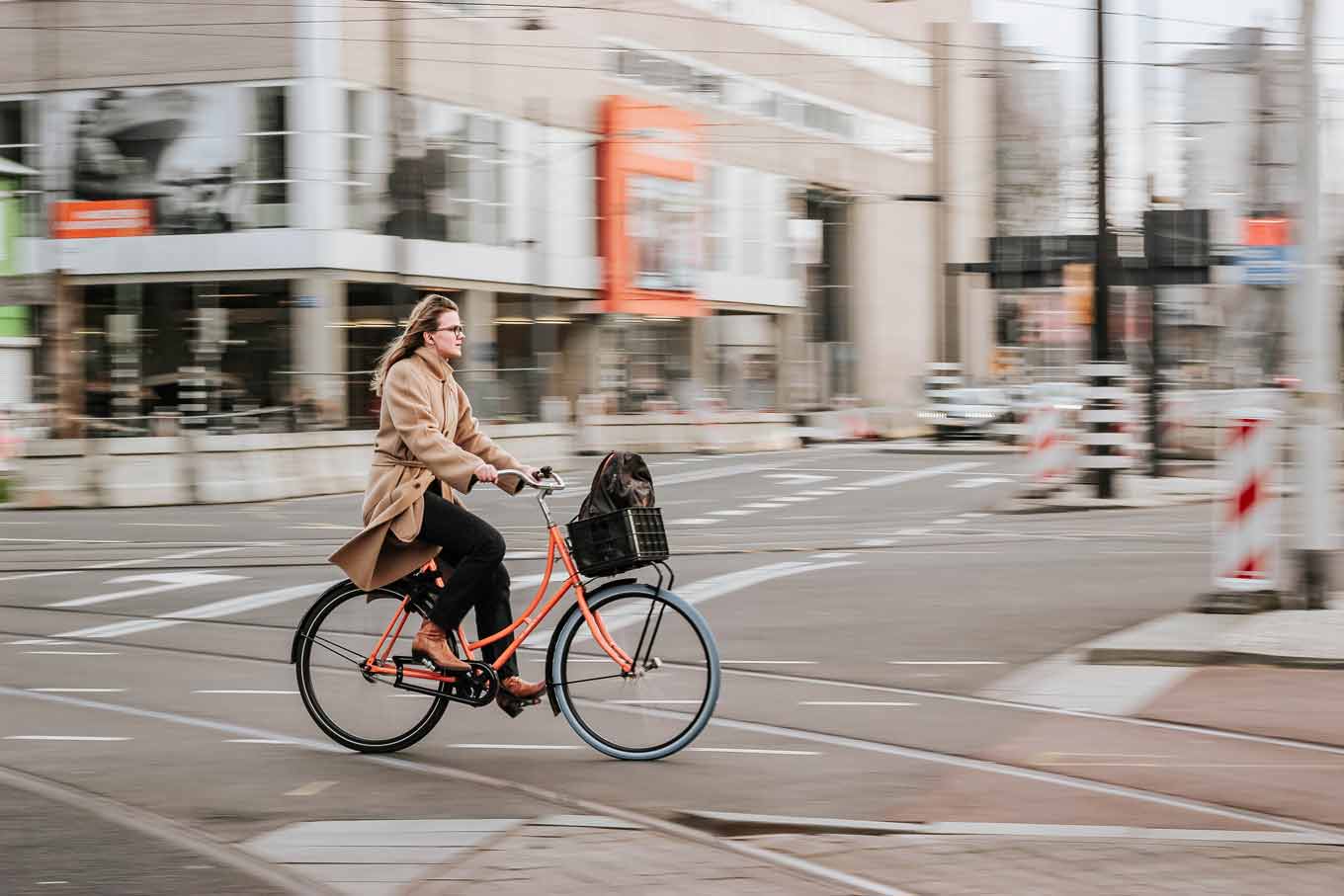 A woman on a bike riding across a street