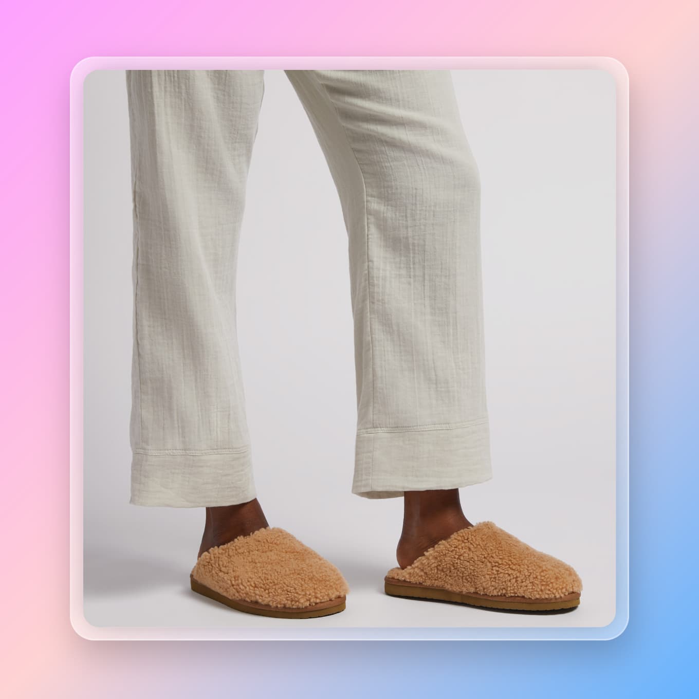 A person wearing white linen pants and fuzzy brown slippers