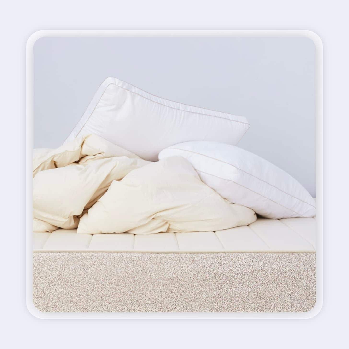 Two white pillows on a bed with a comforter 