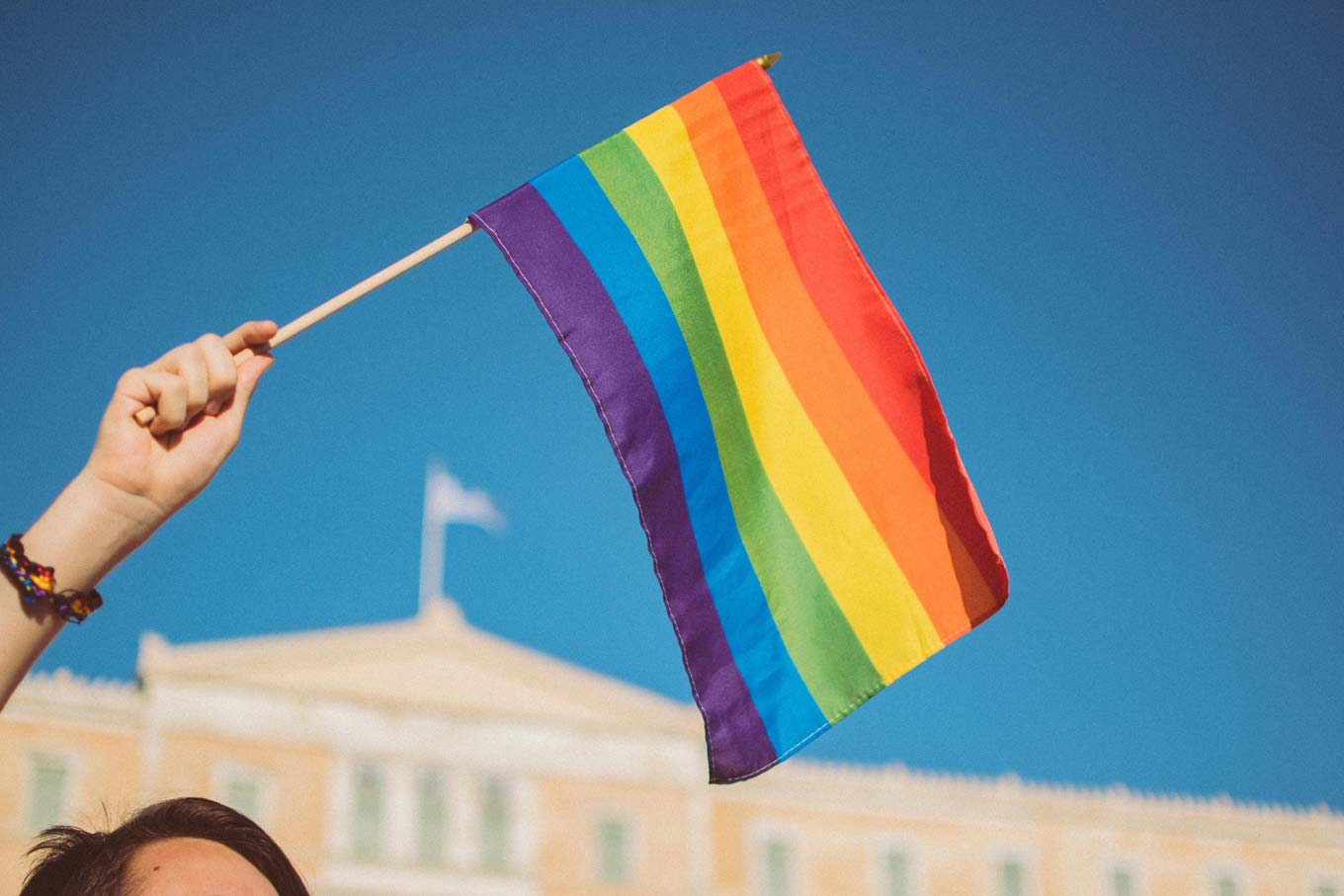 A person waving a rainbow flag