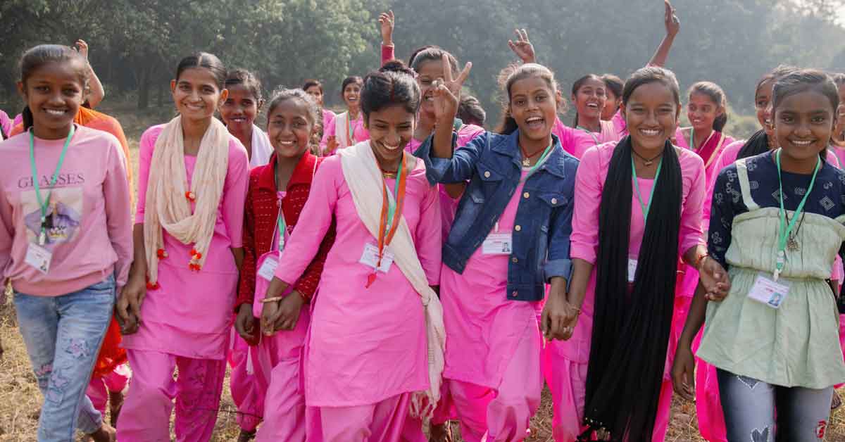 A group of Nepalese girls walk outdoors, smiling and laughing