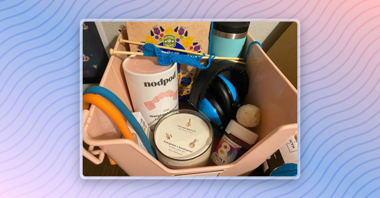 An example self care kit including snacks, water, headphones, a candle, bath bombs, and conversation cards