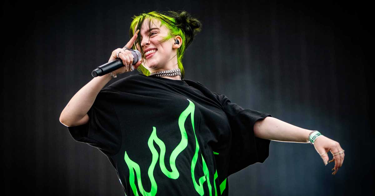 Billie Eilish smiles as she performs on stage