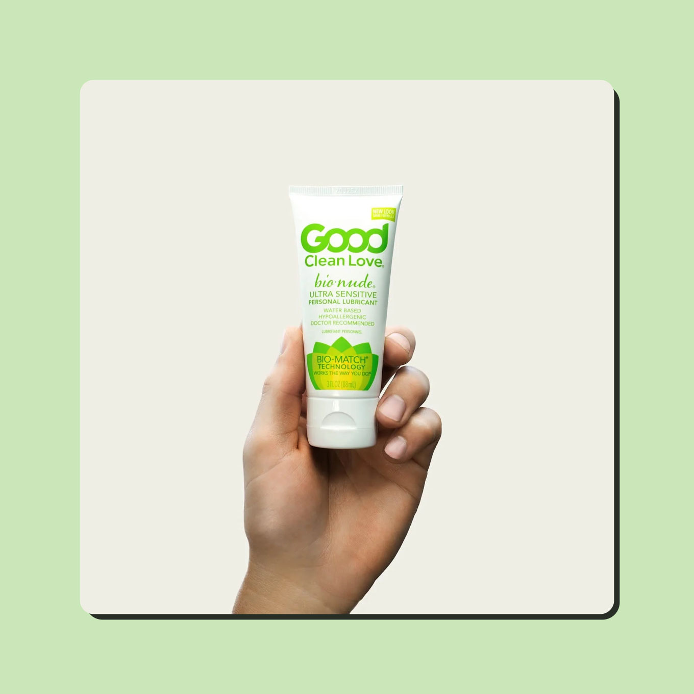 A hand holds up a bottle of Good Clean Love's BioNude lube