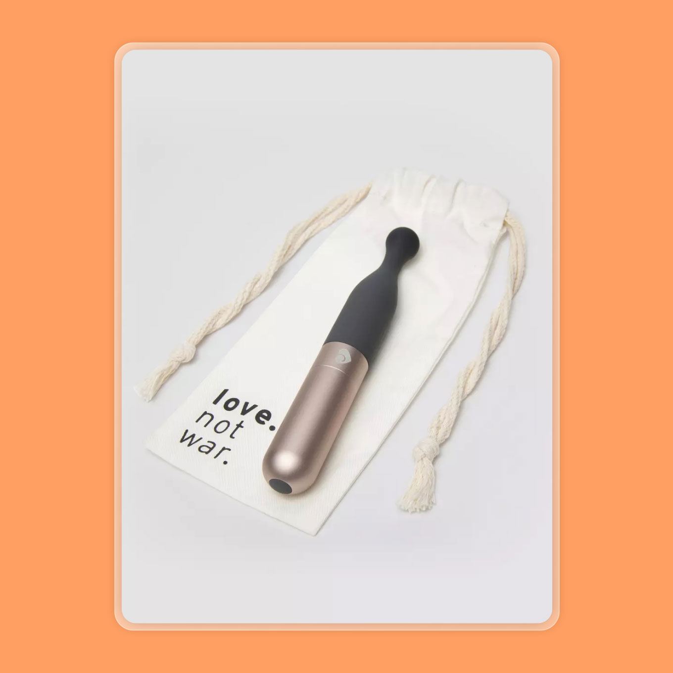 A silver and gray vibrator sits atop a canvas pouch