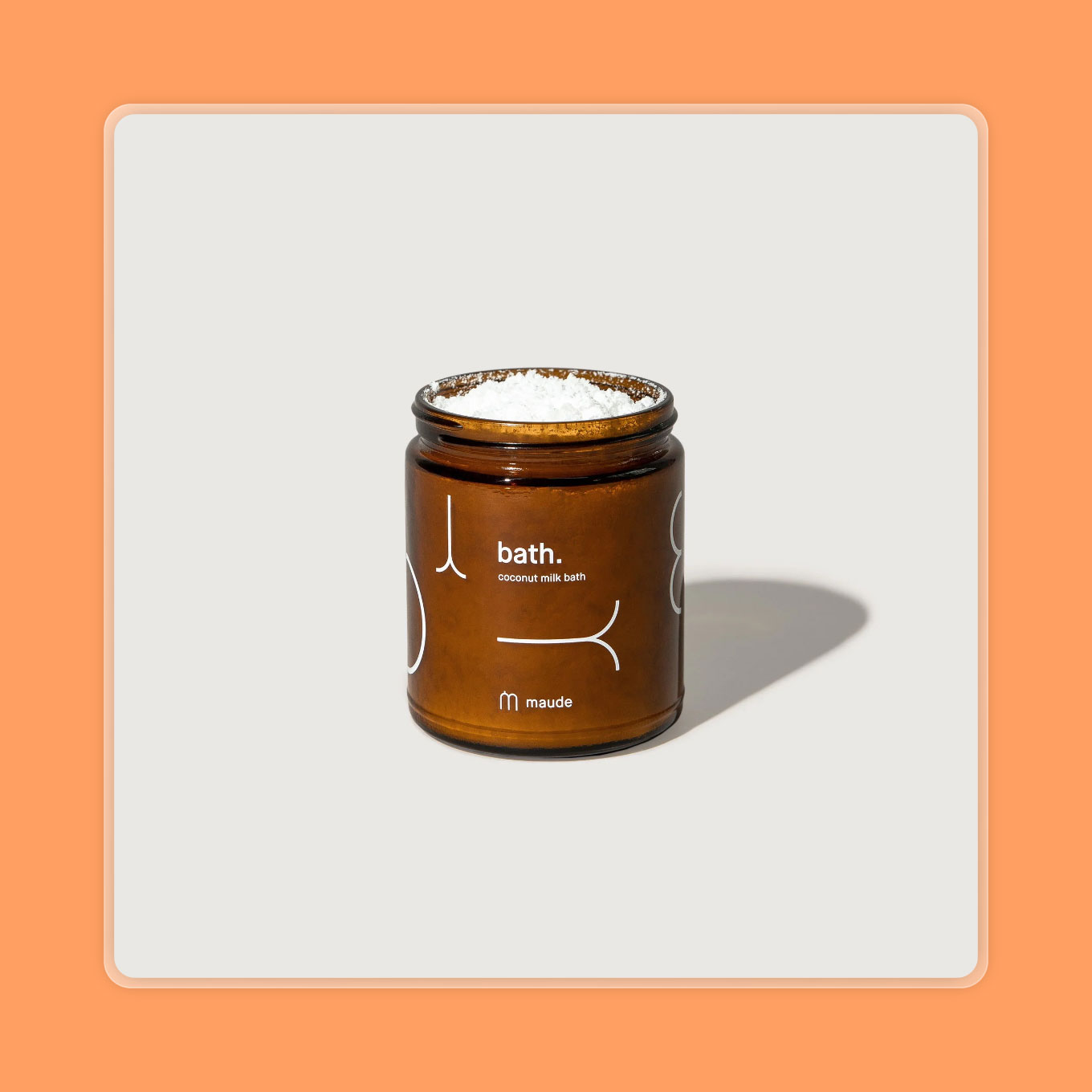 An amber glass jar is filled with a milk bath powder