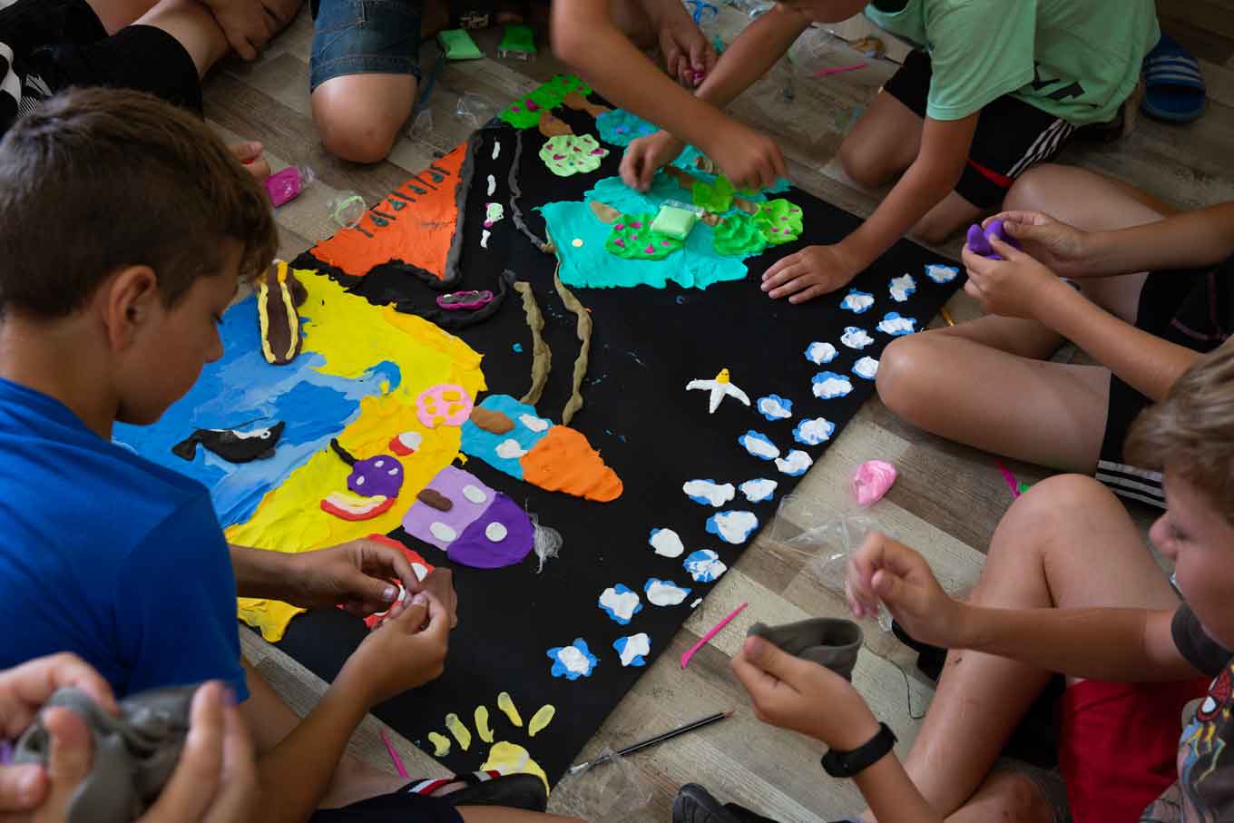 Children work on a craft project with clay and paint