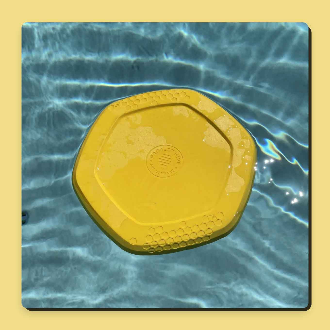 A yellow disc toy floats in blue water