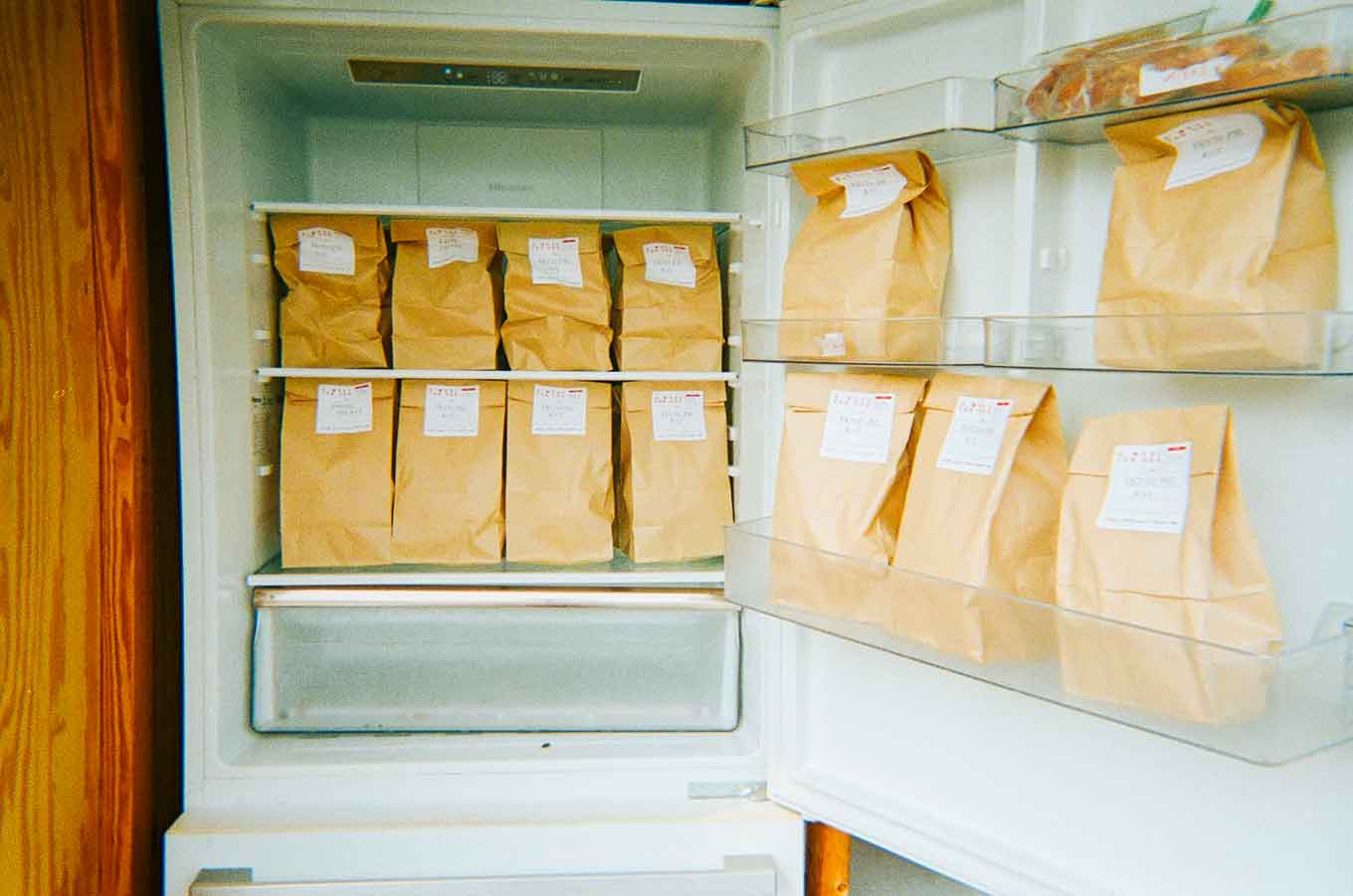A fridge full of brown paper bags