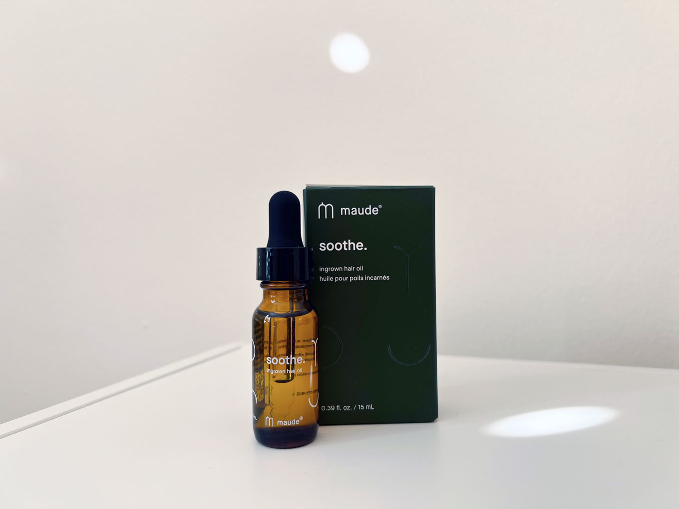A bottle of Soothe from Maude sits on a countertop, next to a box