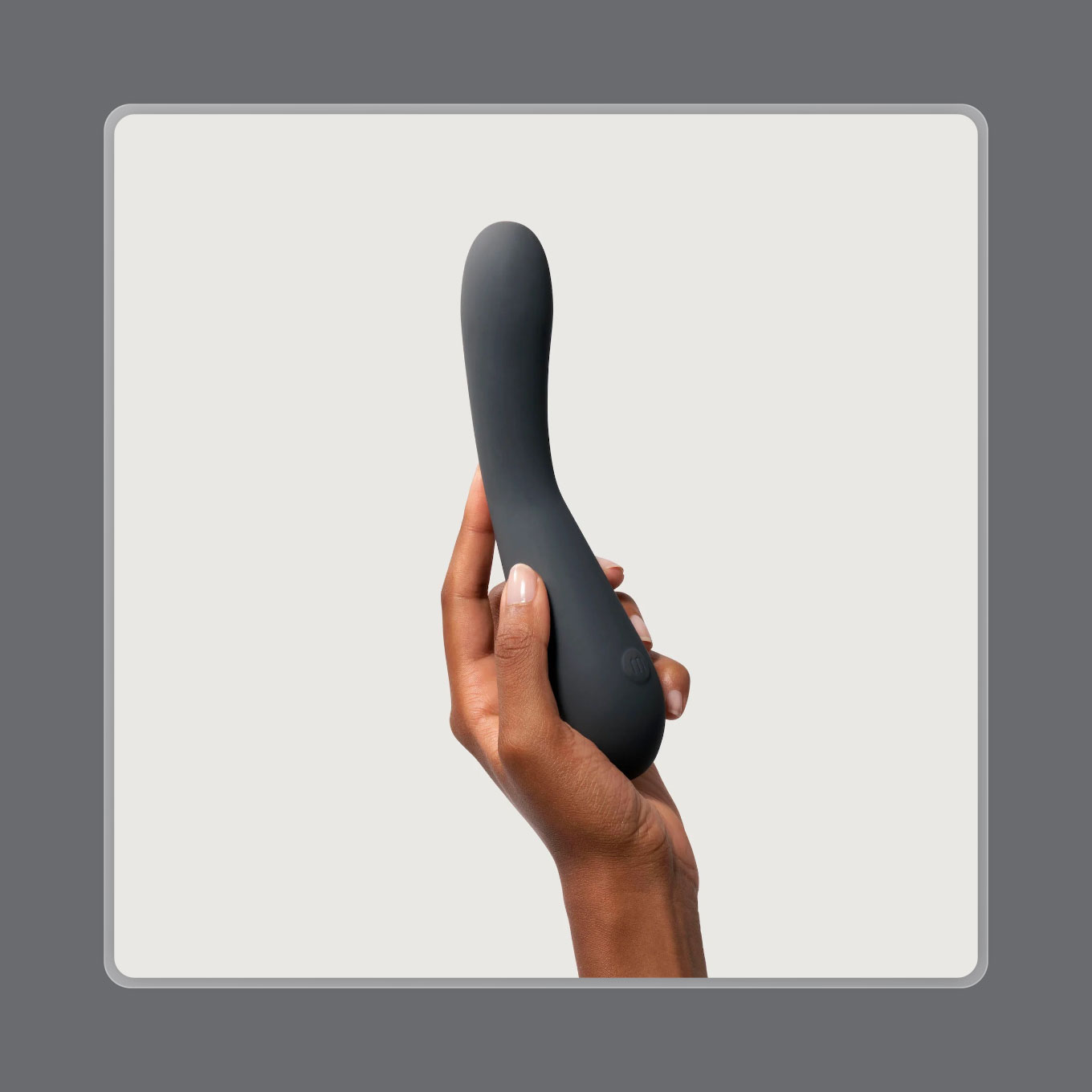 A hand holds up a dark grey vibrator